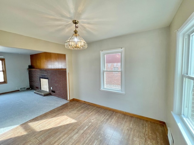 421 Van Dusen St, Springfield, MN 56087 - unfurnished living room with a fireplace, plenty of natural light, baseboards, and wood finished floors