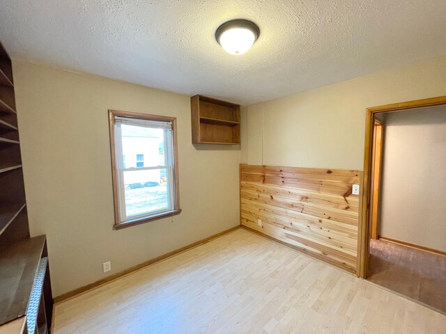 421 Van Dusen St, Springfield, MN 56087 - unfurnished bedroom featuring light wood-type flooring, a textured ceiling, and baseboards