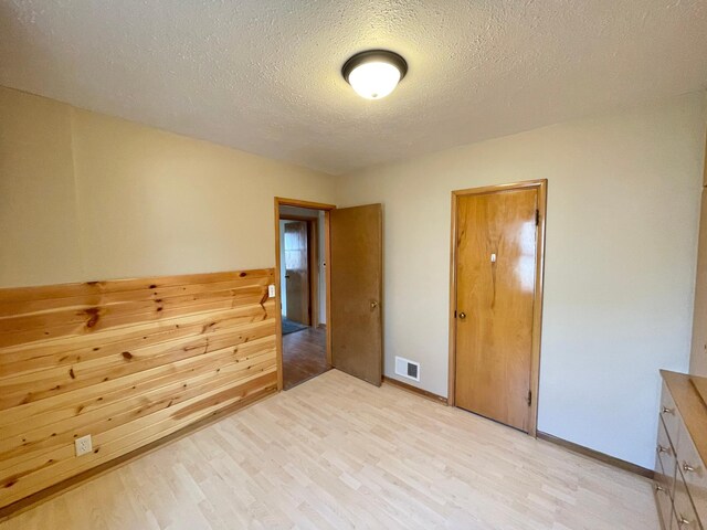 421 Van Dusen St, Springfield, MN 56087 - unfurnished room with light wood-type flooring, a textured ceiling, and baseboards