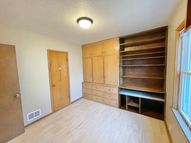 421 Van Dusen St, Springfield, MN 56087 - unfurnished bedroom featuring light wood-type flooring, a textured ceiling, and baseboards
