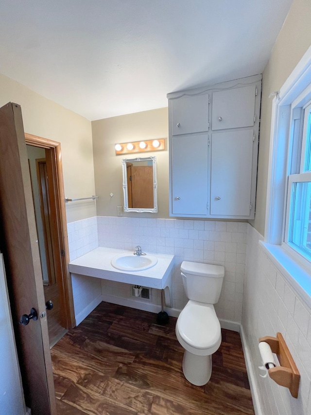 421 Van Dusen St, Springfield, MN 56087 - bathroom with a sink, wood finished floors, toilet, tile walls, and a wainscoted wall
