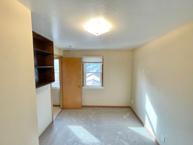 421 Van Dusen St, Springfield, MN 56087 - unfurnished bedroom with light carpet, a textured ceiling, and baseboards