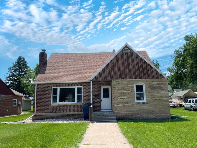 421 Van Dusen St, Springfield, MN 56087 - view of front of house featuring a chimney, a front lawn, brick siding, and roof with shingles