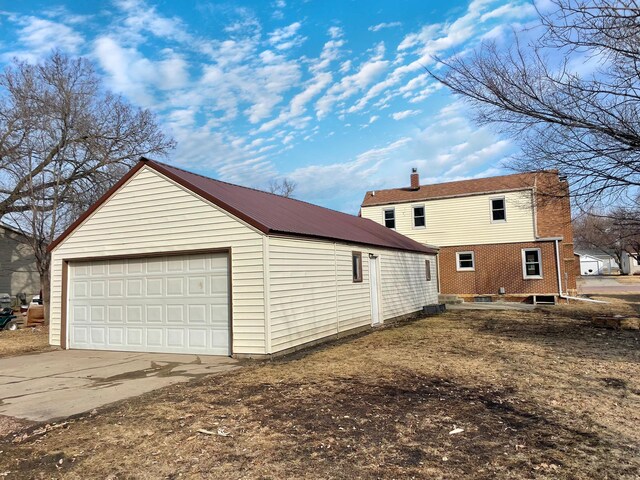 421 Van Dusen St, Springfield, MN 56087 - view of side of home featuring an outdoor structure, a detached garage, metal roof, and a chimney