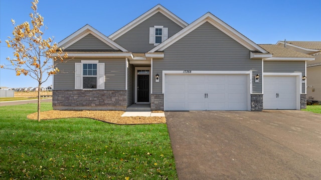 view of front of house featuring stone siding, an attached garage, driveway, and a front yard