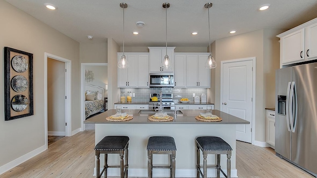 kitchen with decorative backsplash, appliances with stainless steel finishes, a kitchen bar, and a sink