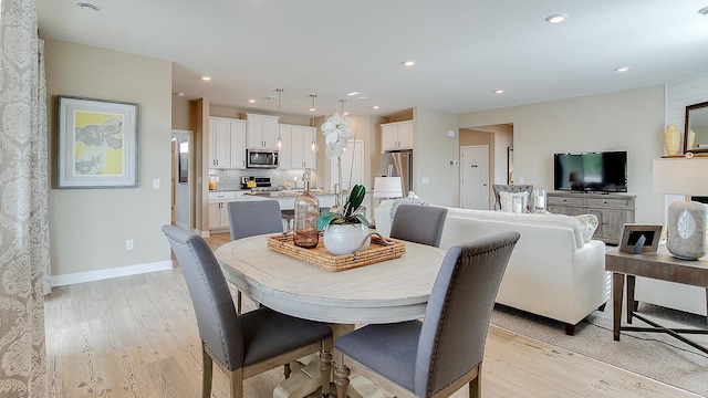 dining room with light wood finished floors, recessed lighting, and baseboards