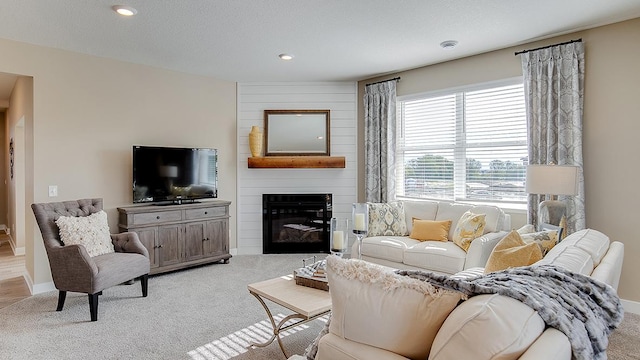 carpeted living room featuring recessed lighting, baseboards, a textured ceiling, and a fireplace