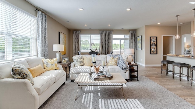 living area featuring light wood-style flooring, recessed lighting, and baseboards