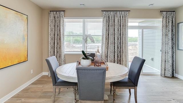 dining area featuring baseboards and light wood-style flooring