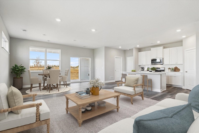 living room featuring recessed lighting, baseboards, and dark wood-type flooring