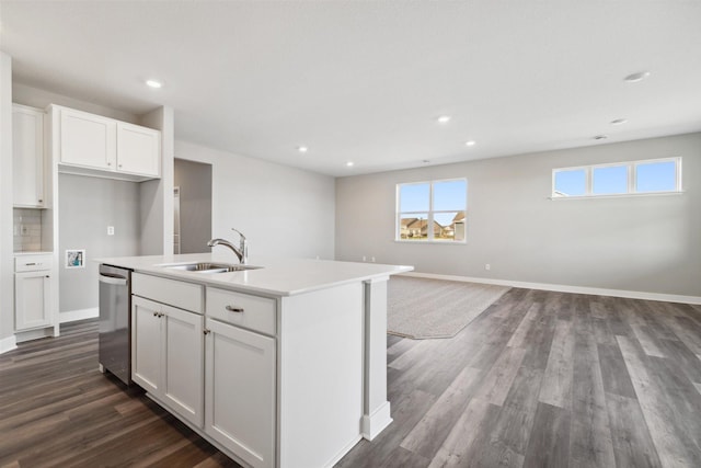 kitchen featuring a kitchen island with sink, a sink, stainless steel dishwasher, dark wood-style floors, and white cabinetry