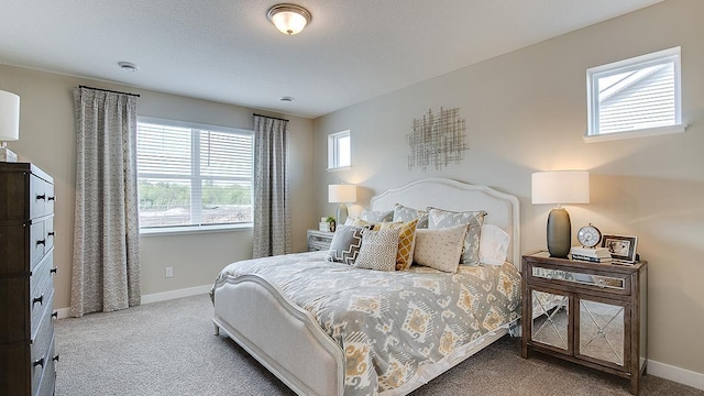 carpeted bedroom featuring baseboards and a textured ceiling