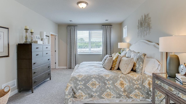 bedroom featuring light colored carpet, a textured ceiling, and baseboards