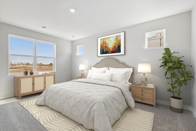 bedroom with light colored carpet and baseboards