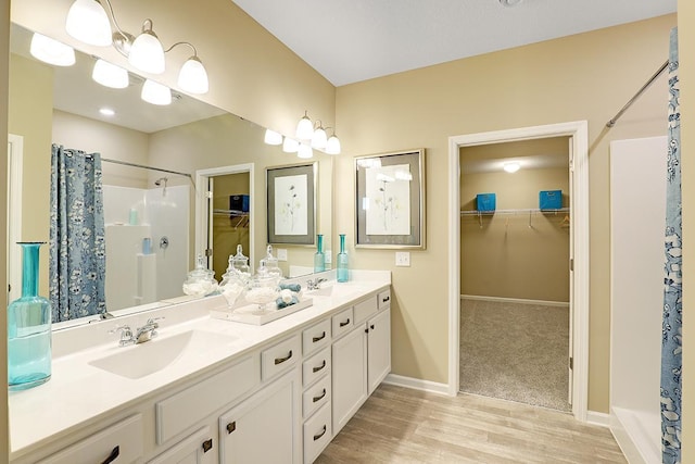 full bath with double vanity, a shower with shower curtain, baseboards, and a sink