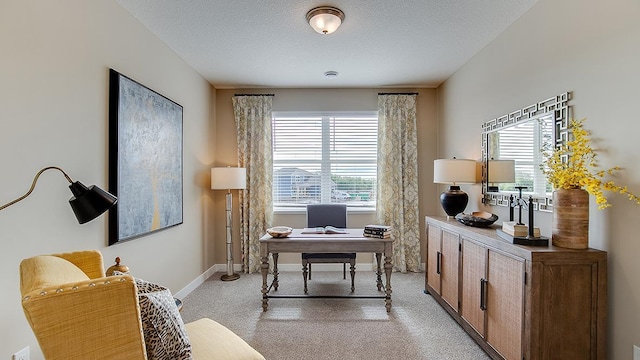 home office with light carpet, baseboards, and a textured ceiling