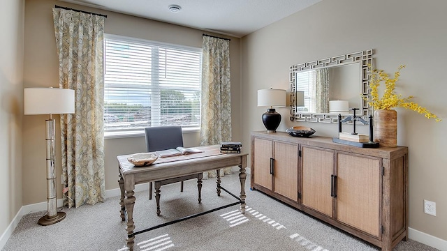 office space featuring light carpet and baseboards