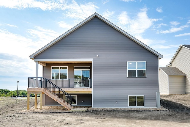 back of property with covered porch and stairs