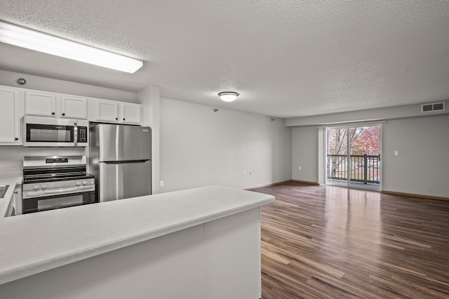 kitchen with visible vents, dark wood finished floors, open floor plan, white cabinets, and stainless steel appliances