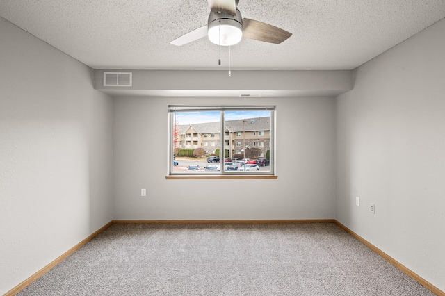 unfurnished room with visible vents, carpet flooring, baseboards, and a ceiling fan