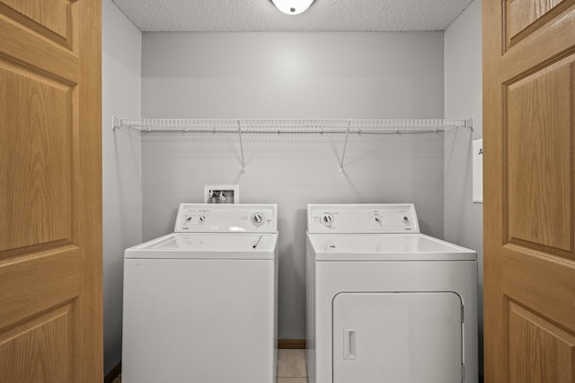 washroom featuring laundry area, washing machine and dryer, and a textured ceiling