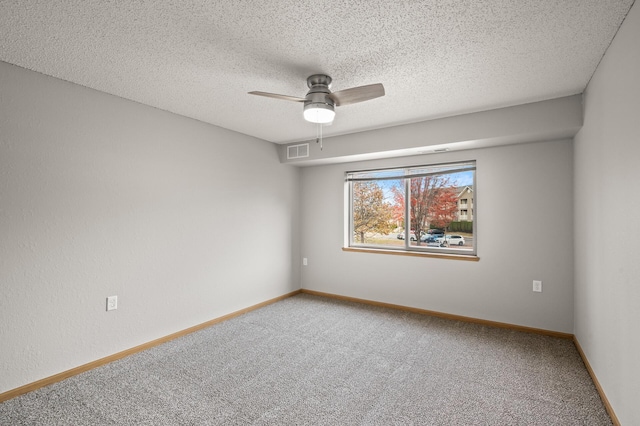 carpeted spare room featuring visible vents, baseboards, a textured ceiling, and a ceiling fan