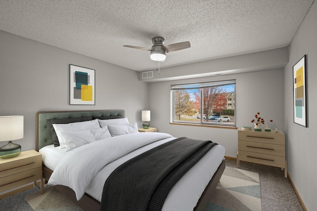 bedroom with visible vents, carpet floors, a textured ceiling, and baseboards