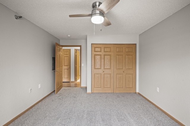 unfurnished bedroom with ceiling fan, baseboards, carpet flooring, a closet, and a textured ceiling