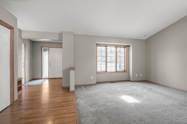 carpeted spare room with lofted ceiling and baseboards