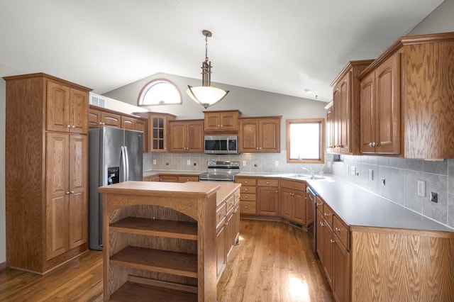 kitchen featuring open shelves, light wood-style floors, appliances with stainless steel finishes, and a sink