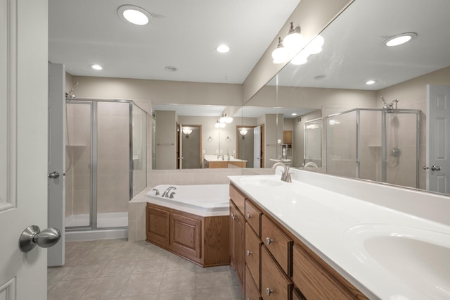 bathroom featuring a garden tub, a sink, a shower stall, tile patterned flooring, and double vanity