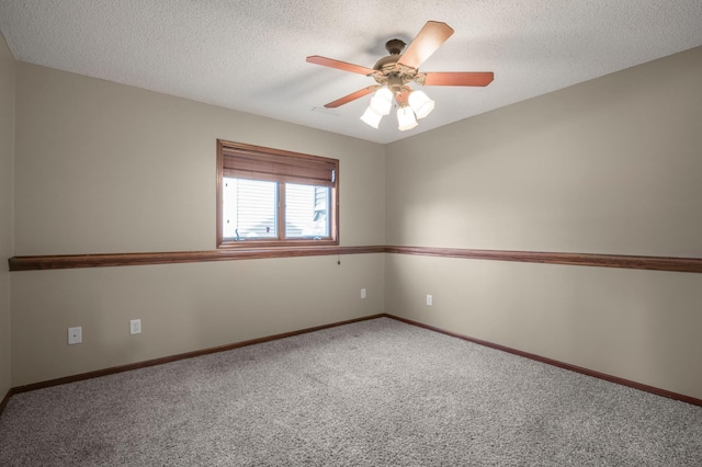 spare room with a textured ceiling, carpet, baseboards, and ceiling fan