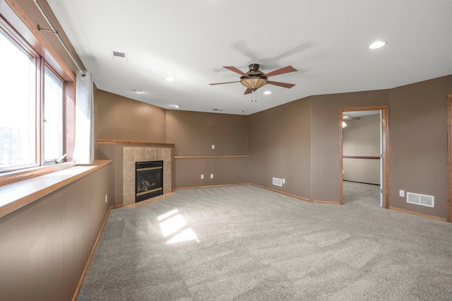 unfurnished living room featuring visible vents, recessed lighting, baseboards, ceiling fan, and a tile fireplace