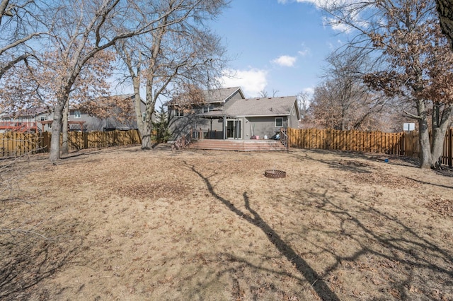 rear view of house with a fenced backyard and a wooden deck