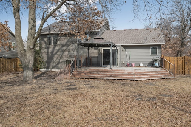 back of house featuring a gazebo, a wooden deck, and fence