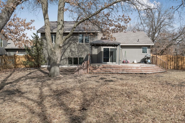 back of property featuring a gazebo, a deck, roof with shingles, and a fenced backyard