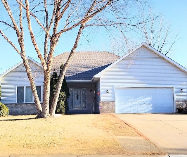 ranch-style home with brick siding, concrete driveway, an attached garage, and a shingled roof