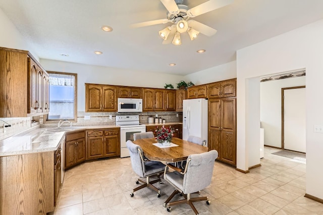 kitchen featuring baseboards, light countertops, decorative backsplash, brown cabinets, and white appliances