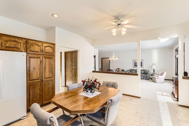 dining space with baseboards and ceiling fan with notable chandelier