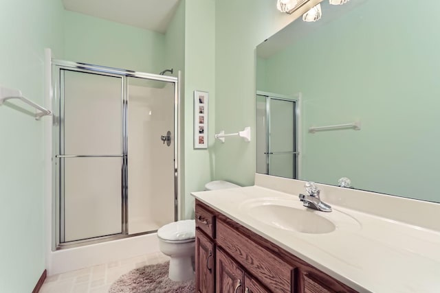 bathroom featuring vanity, tile patterned floors, toilet, and a stall shower