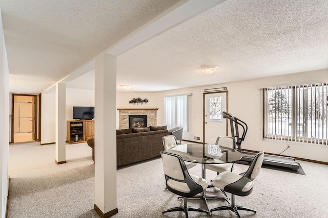 dining space with baseboards, carpet floors, a textured ceiling, and a fireplace