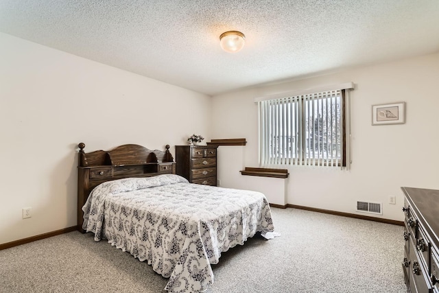 bedroom with carpet flooring, baseboards, visible vents, and a textured ceiling