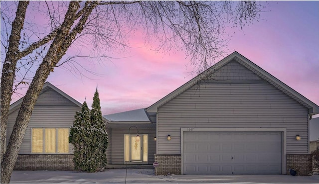 view of front of home with concrete driveway, brick siding, and a garage