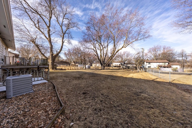 view of yard with central air condition unit, fence, and a wooden deck