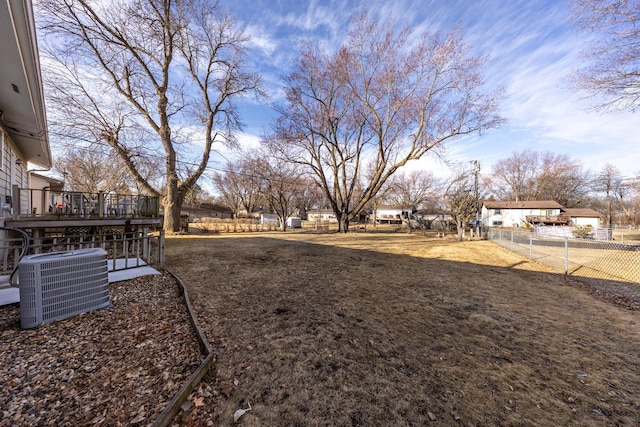 view of yard featuring cooling unit, a wooden deck, and fence