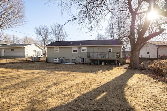 rear view of property featuring central AC unit, fence, a lawn, and a wooden deck