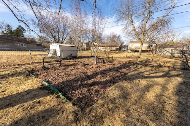 view of yard with an outbuilding, a storage shed, and fence