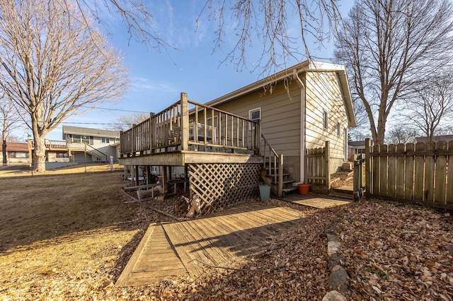 back of property with stairway, a deck, and fence