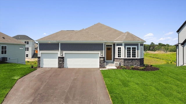 view of front of home featuring aphalt driveway, a front yard, cooling unit, a garage, and stone siding